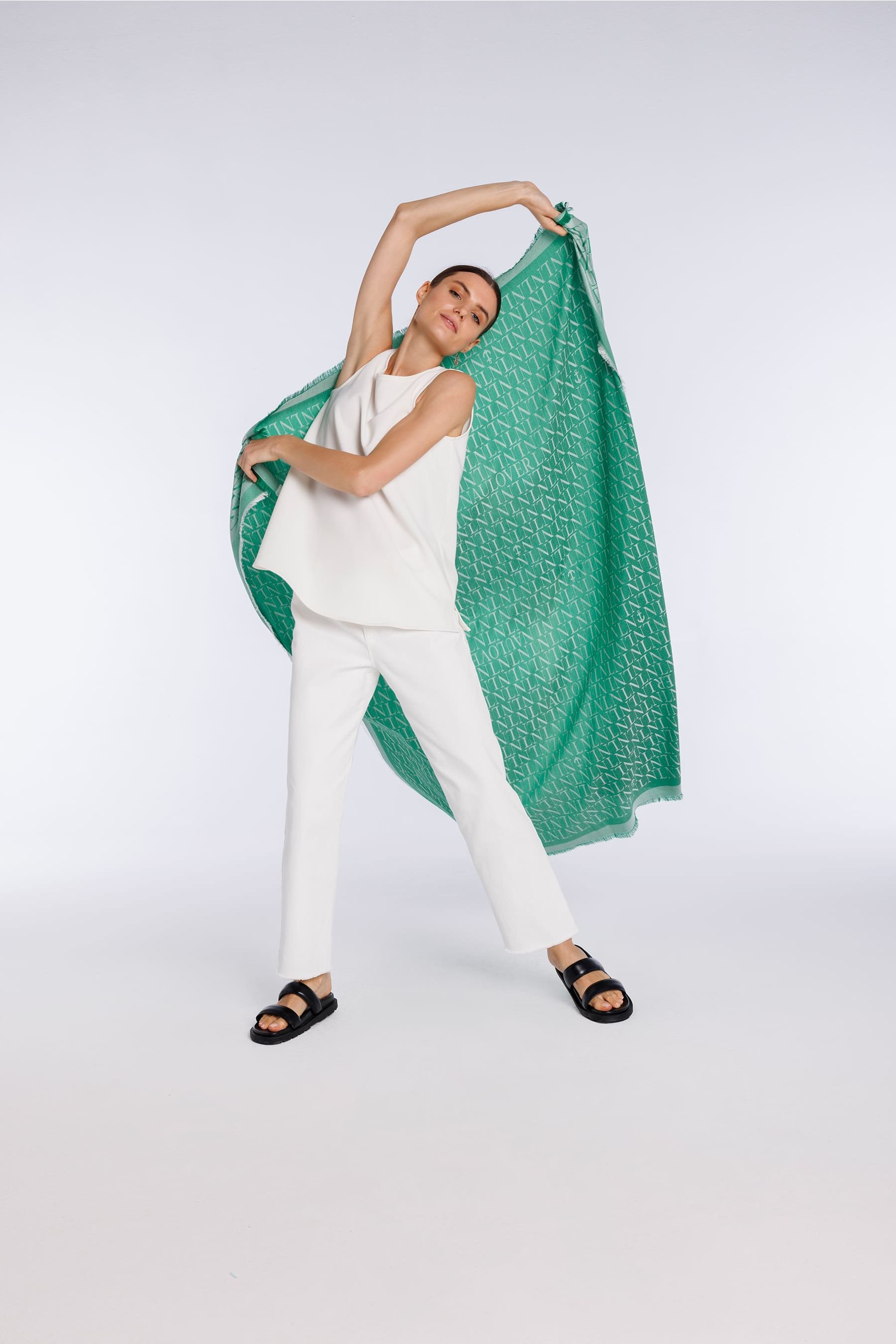 Conjunto blanco de blusa y pantalón combinado con un fular verde