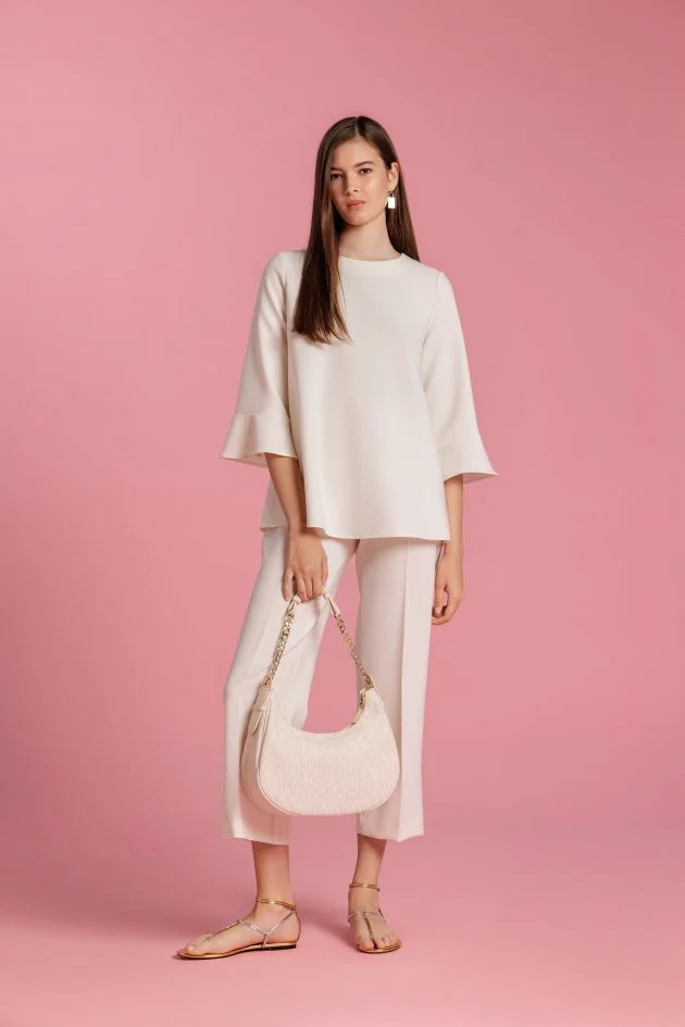 Total look en blanco de blusa, pantalón y bolso de media luna